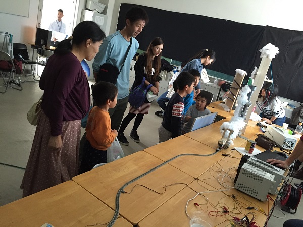 2014年度の電気情報工学科展示を来場者が楽しんでくださっていることが、写真から分かります。