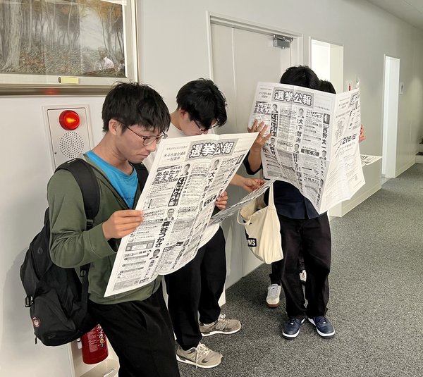 選挙公報を読む学生.jfif